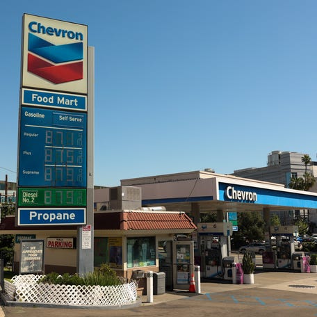 Pedestrians walk past gas prices starting at $8.71 per gallon at a Chevron gas station on Alameda Ave near Union Station in Los Angeles, California on March 20, 2026. (Photo by Patrick T. Fallon / AFP via Getty Images)