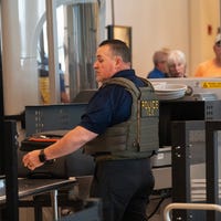 Members of U.S. Immigration and Customs Enforcement (ICE) work and interact with travelers in the security line at Southwest Florida International Airport on March 25, 2026.