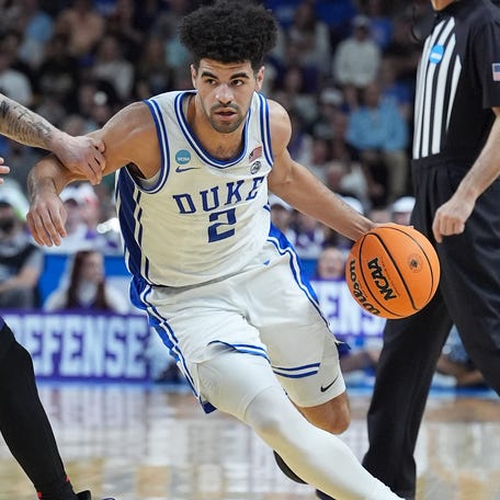 Duke guard Cayden Boozer (2) dribbles the ball against the defense of TCU guard Brock Harding (2) during the second round of the 2026 men's tournament at Bon Secours Wellness Arena.