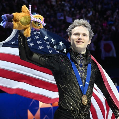 USA's Ilia Malinin celebrates with the U.S. flag after winning the men's free skating program of the 2026 ISU Figure Skating World Championships in Prague, Czech Republic on March 28, 2026.