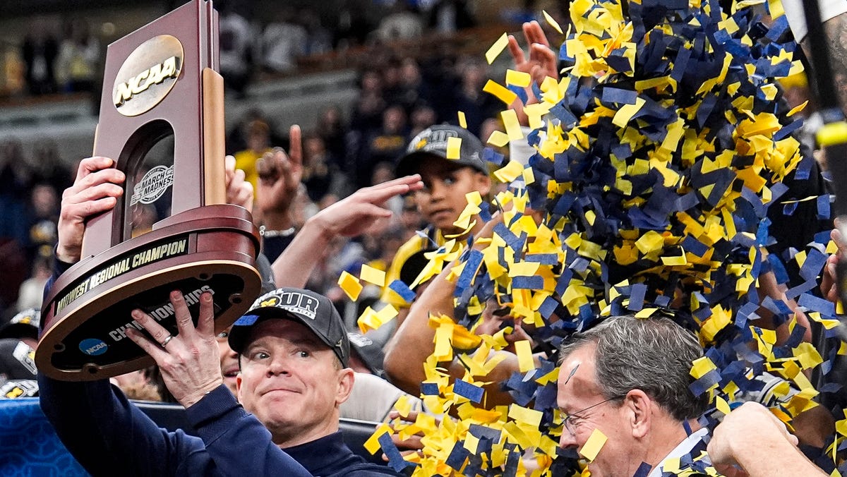 Michigan head coach Dusty May hoist up the NCAA Tournament Midwest Regional Championship trophy after 95-62 win over Tennessee at United Center in Chicago on Sunday, March 29, 2026.