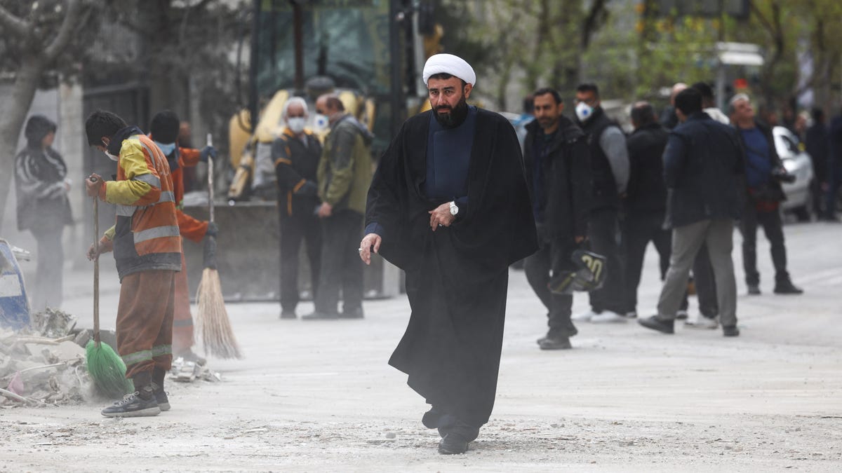 An Iranian cleric walks at the site of the Qatari Al-Araby TV and business building damaged by a strike, as the U.S.-Israeli conflict with Iran continues, in Tehran, Iran, March 29, 2026.
