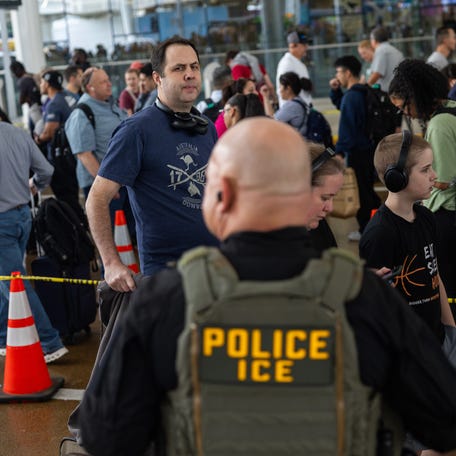 Travelers pass an Immigration and Customs Enforcement (I.C.E.) agent while waiting in line at Terminal E at George Bush Intercontinental Airport on March 24, 2026 in Houston, Texas. The travel disruptions continue as hundreds of TSA agents quit or work without pay during a partial government shutdown. U.S. President Donald Trump said ICE agents will be deployed to U.S. airports on Monday, with border czar Tom Homan in charge of the effort.
