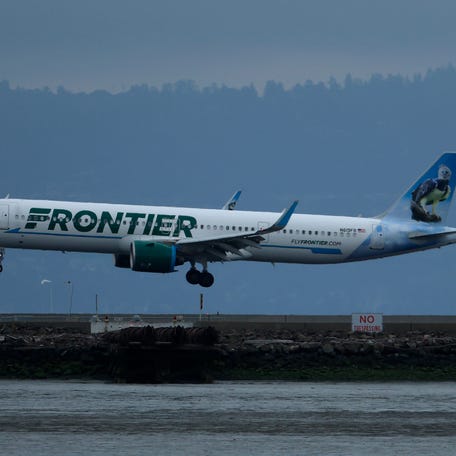 A Frontier Airlines plane is pictured landing.