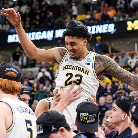 Michigan players pick up forward Yaxel Lendeborg (23) to celebrate winning the NCAA Tournament Midwest Regional Championship trophy after a 95-62 win over Tennessee at United Center in Chicago on Sunday, March 29, 2026.