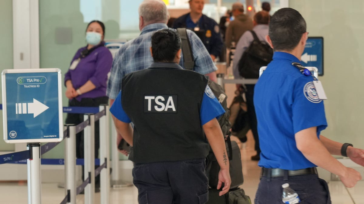 TSA workers as a security screening checkpoint at Denver International Airport.