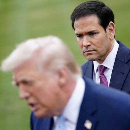 Secretary of State Marco Rubio listens to President Donald Trump speaking to reporters in Washington, DC, on March 20, 2026, as Trump departs the White House for Florida.