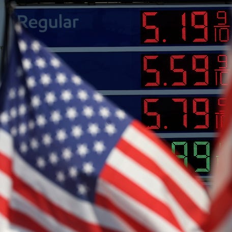 Gasoline prices are displayed at an Exxon gas station behind American flag in Edgewater, New Jersey, U.S., June 14, 2022. REUTERS/Mike Segar