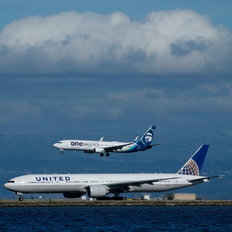 An Alaska Airlines plane lands next to a departing United Airlines plane at San Francisco International Airport (SFO) on November 07, 2025 in San Francisco, California.