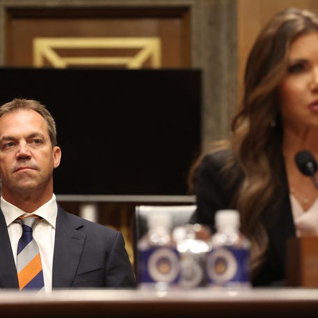 Bryon Noem (L), husband of US Secretary of Homeland Security Kristi Noem (R), listens as Secretary Noem testifies before the Senate Committee on Homeland Security and Governmental Affairs on Capitol Hill in Washington, DC on May 20, 2025.