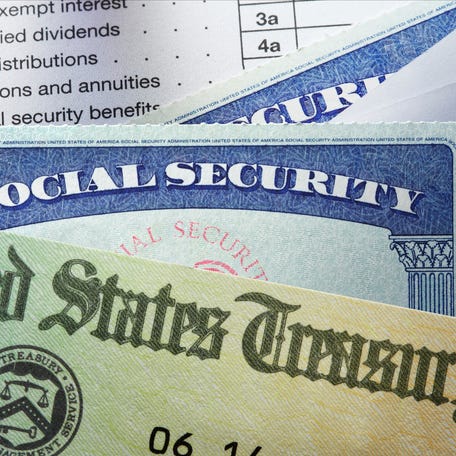 A United States Treasury government check and two social security cards resting on top of a United States federal 1040 tax return.