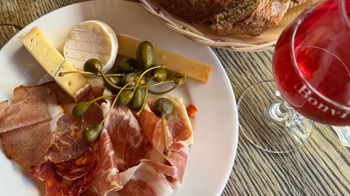 Assorted French cheeses and meats are served alongside bread and Kir at Bonvivant in Paris.