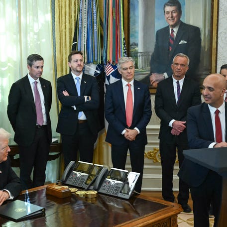 President Donald Trump (L) looks on as Maziar Mike Doustdar, CEO of Novo Nordisk, speaks in the Oval Office during an event about weight-loss drugs at the White House in Washington, DC on November 6, 2025.