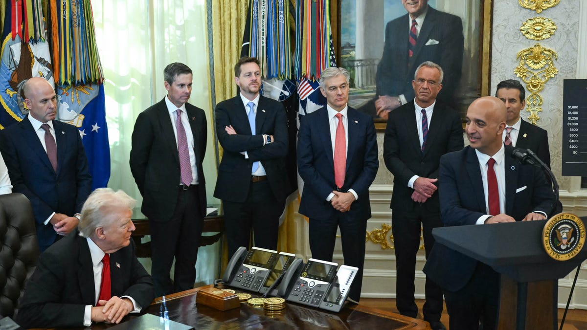 President Donald Trump (L) looks on as Maziar Mike Doustdar, CEO of Novo Nordisk, speaks in the Oval Office during an event about weight-loss drugs at the White House in Washington, DC on November 6, 2025.