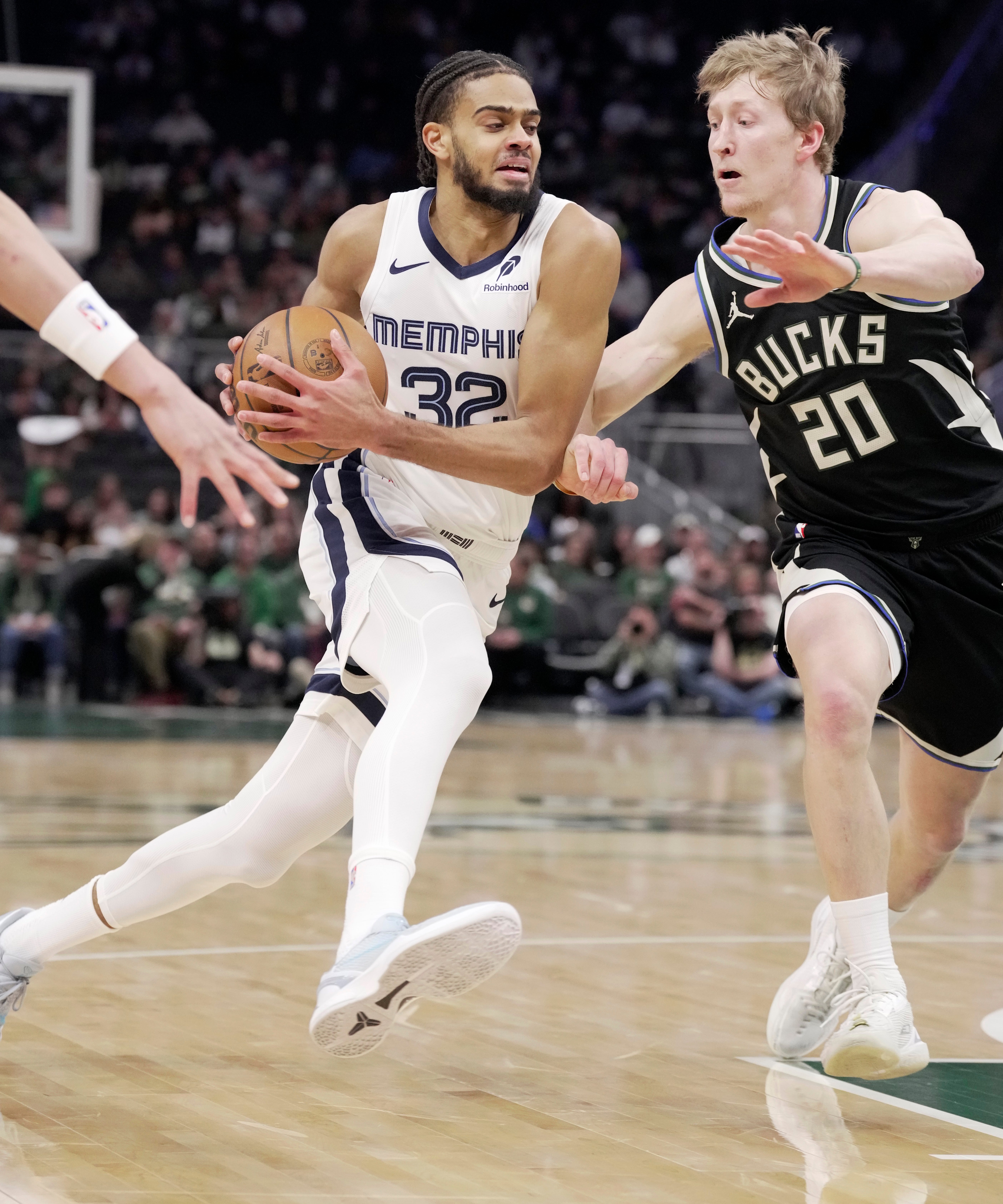 Memphis Grizzlies Rayan Rupert (32) forward drives on Milwaukee Bucks guard AJ Green (20) during the first half of their game Sunday, April 5, 2026 at Fiserv Forum in Milwaukee, Wisconsin.