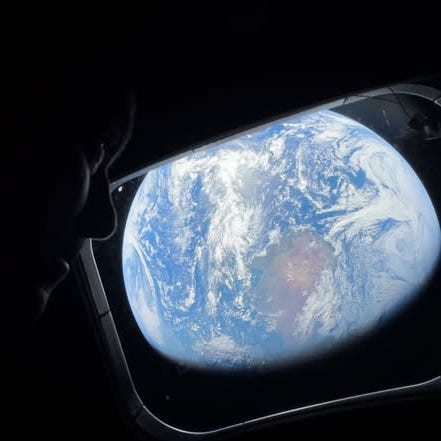 Artemis II commander Reid Wiseman gazes out at Earth through a window of the Orion spacecraft in April 2026.