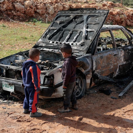 Palestinian children on April 6, 2026, inspect a destroyed car, which Palestinians say was burned by Israeli settlers the night before, near Nablus in the Israeli-occupied West Bank.