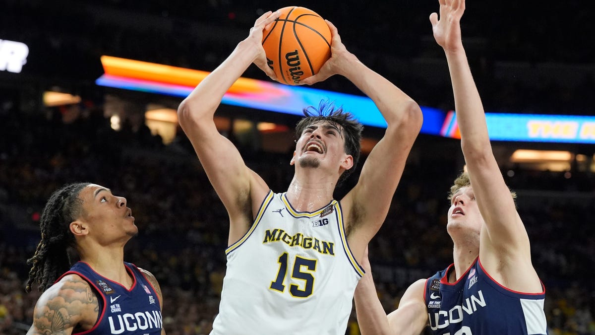 Michigan center Aday Mara (15) looks for a basket around Connecticut guard Solo Ball (1) and center Eric Reibe (12) during the first half of the 2026 NCAA men's tournament national championship game at Lucas Oil Stadium in Indianapolis on Monday, April 6, 2026.