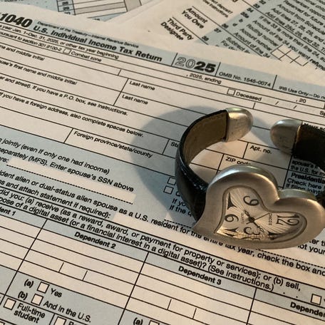 A Form 1040 is pictured under a watch. U.S. taxpayers use the form to file an annual income tax return.