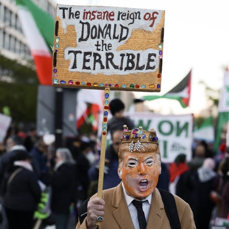 A protester wears a President Donald Trump mask at a demonstration against military action in Iran in Washington, DC, on April 7, 2026.