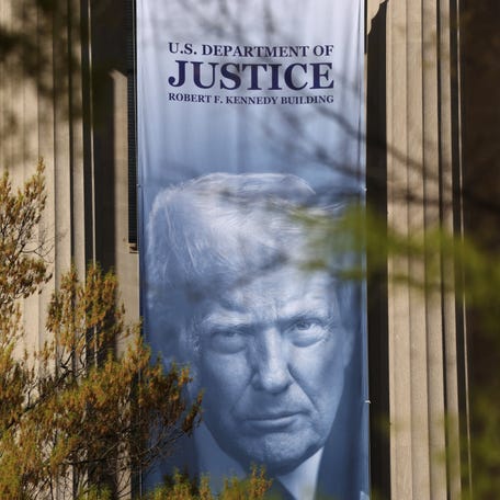 A banner of President Donald Trump hangs from the U.S. Department of Justice in Washington, DC, on April 6, 2026.