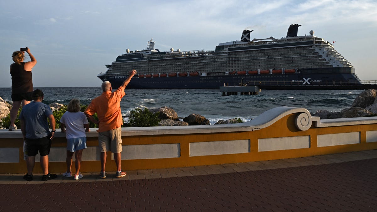 Tourists look at the Celebrity Silhouette cruise ship, from the old town of Willemstad, Curacao, in the Dutch Caribbean, on April 7, 2026.