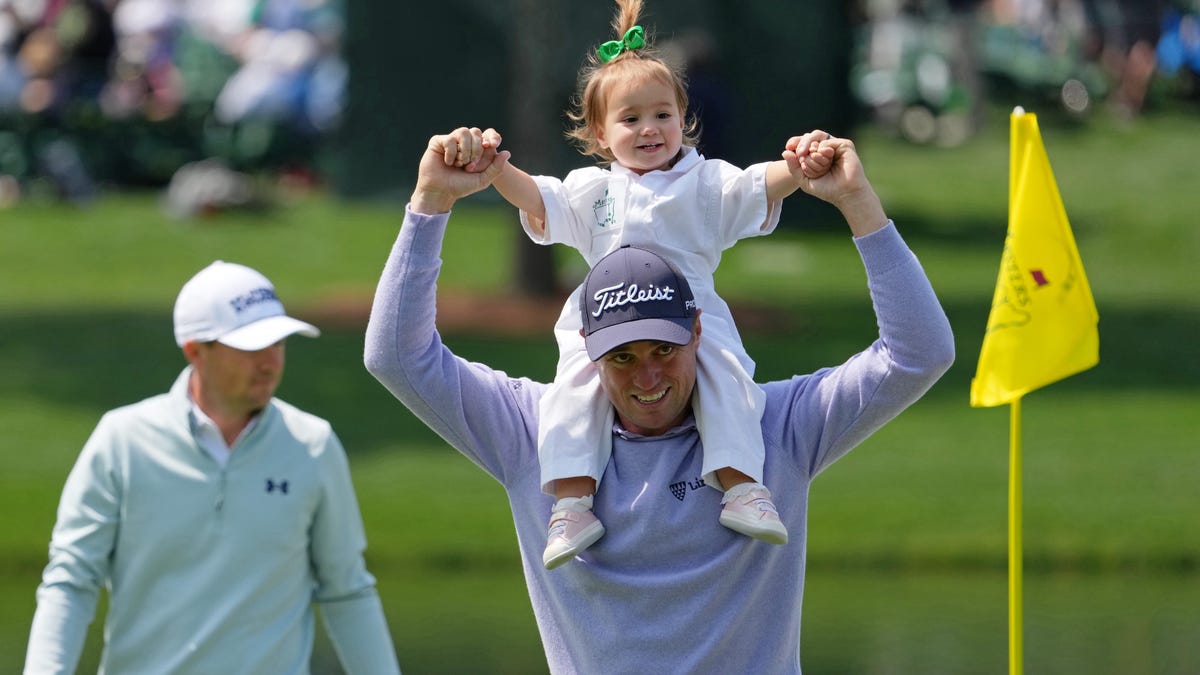 Justin Thomas celebrates with wife Jillian and daughter after a hole-in-one during the Par 3 Contest ahead of the 2026 Masters at Augusta National.