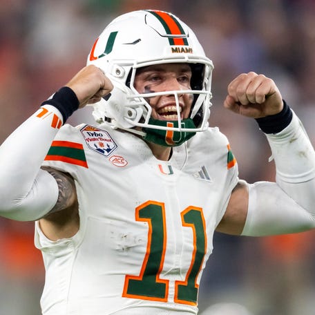 Jan 8, 2026; Glendale, AZ, USA; Miami Hurricanes quarterback Carson Beck (11) flexes his arms as he celebrates against the Mississippi Rebels during the 2026 Fiesta Bowl and semifinal game of the College Football Playoff at State Farm Stadium. Mandatory Credit: Mark J. Rebilas-Imagn Images