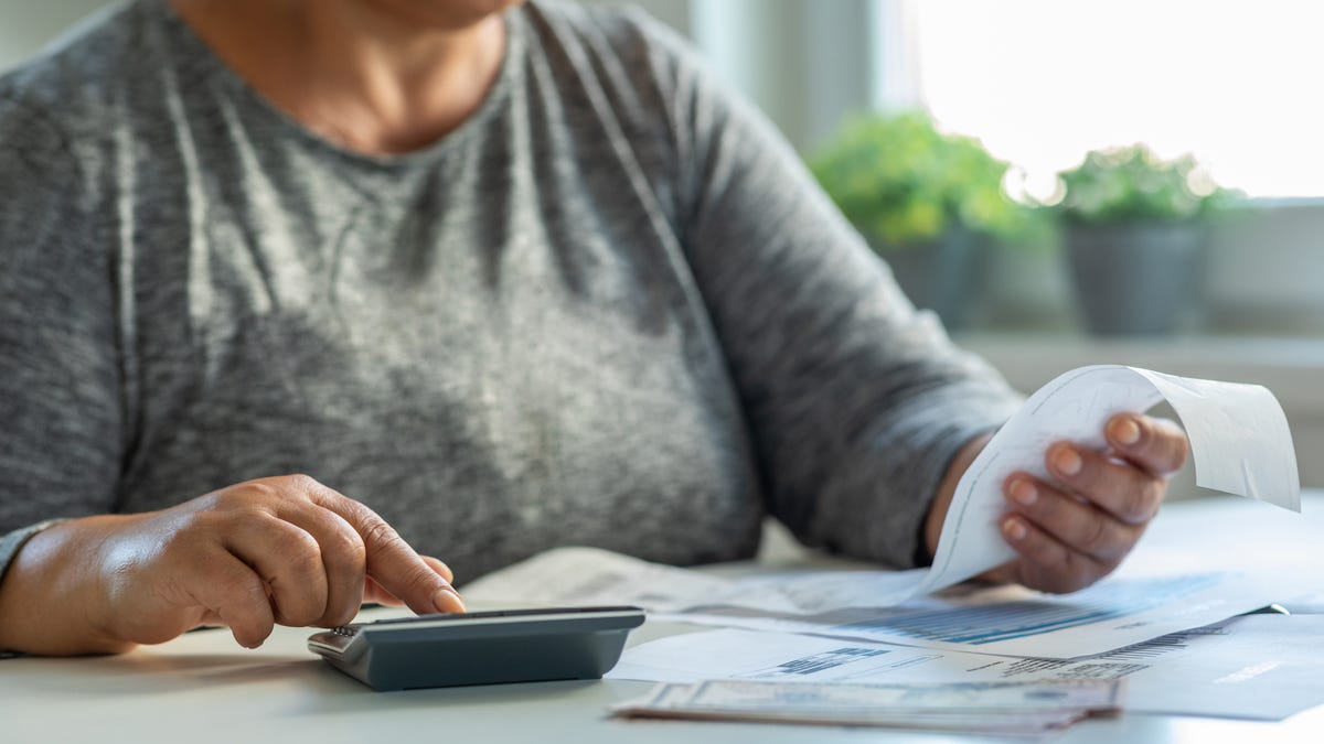 Mature woman checking her energy bills on table