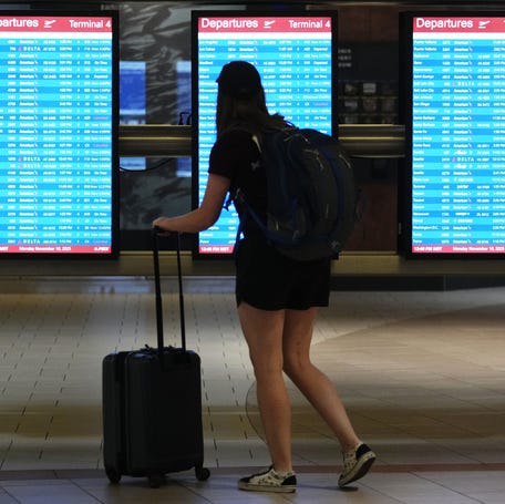 A passenger looks at the departure board in Terminal 4 during the government shutdown at Phoenix Sky Harbor International Airport on Nov. 10, 2025. So far, travelers this year aren't seeing major flight impacts from the Iran war.