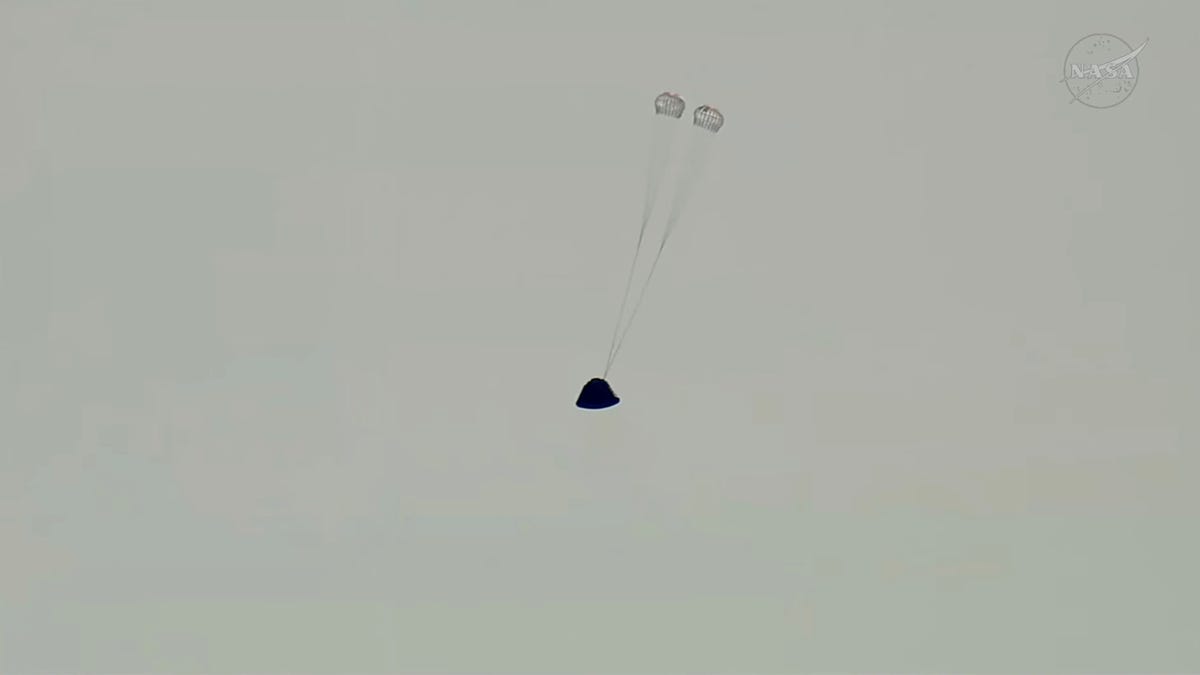 The first set of parachutes deploys on the Artemis II crew capsule in this screengrab from a livestream video as it descends toward splashdown following its re‑entry to Earth after the Artemis II crew’s flyby of the Moon, April 10, 2026.