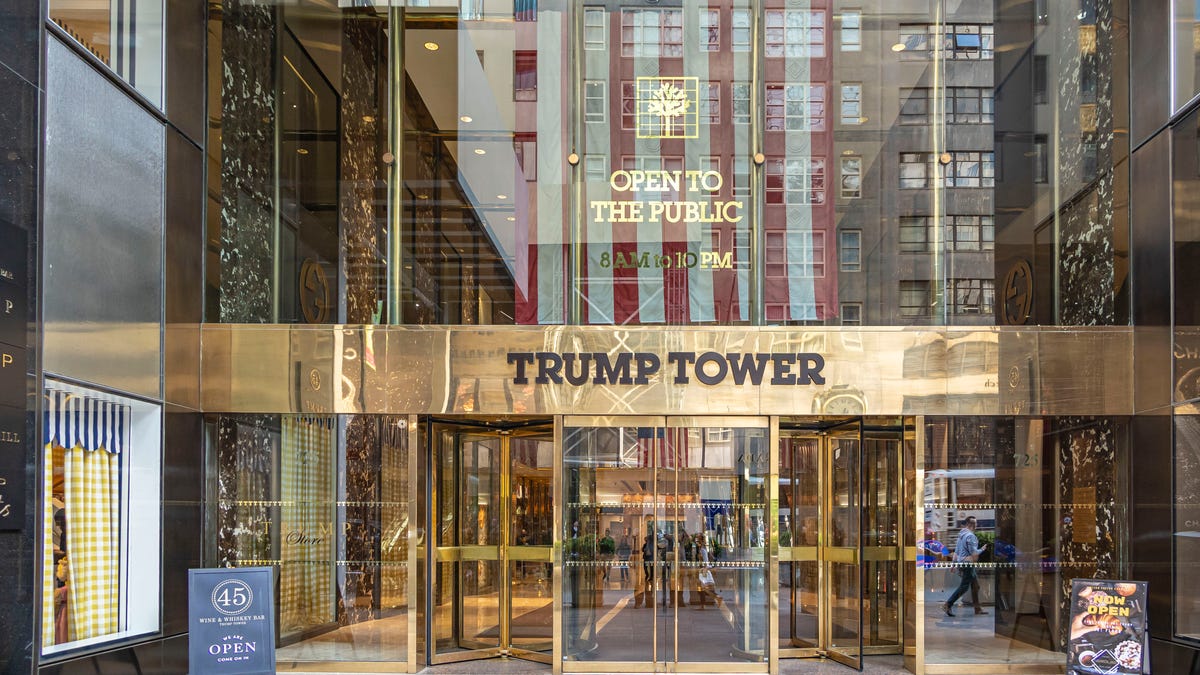 The main entrance of Trump Tower with the inscription on it and a US flag in New York City in the United States of America.