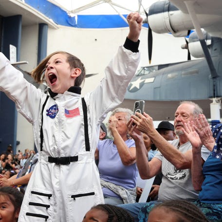 Crowds watch the Artemis II Orion capsule splash down off the coast of San Diego at the Air and Space Museum in San Diego, California, on April 10, 2026.