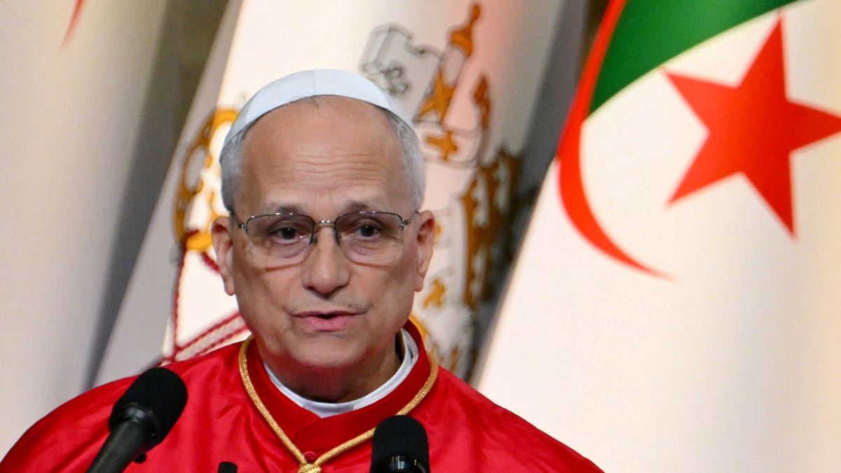 Pope Leo XIV addresses authorities, members of the civil society and the diplomatic corps at the "Djamaa el Djazair" Conference Center on April 13, 2026. Pope Leo XIV embarks today on an 11-day visit to Algeria, Cameroon, Angola and Equatorial Guinea for his first major international trip since becoming pontiff last year. (Photo by Alberto PIZZOLI / AFP via Getty Images)