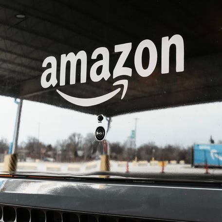 An Amazon tractor trailer is reflected in the grill of the Rivian Amazon EDV at a Louisville, Kentucky warehouse on Jan. 16, 2026.