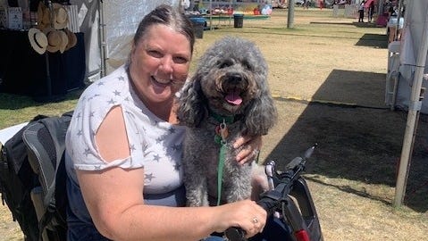 Debi Coleman in her mobility scooter with her service dog, Darby.