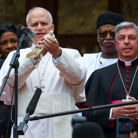 Pope Leo XIV holds a bird next to Archbishop of Bamenda Andrew Fuanya Nkea and other officials after a meeting for peace with the community of Bamenda in Saint Joseph’s Cathedral in Bamenda, Cameroon, April 16, 2026.