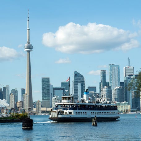 The ferry takes people back to the city from Toronto Island across from the Canadian National Tower and the Toronto skyline on Lake Ontario on Sept. 14, 2023.