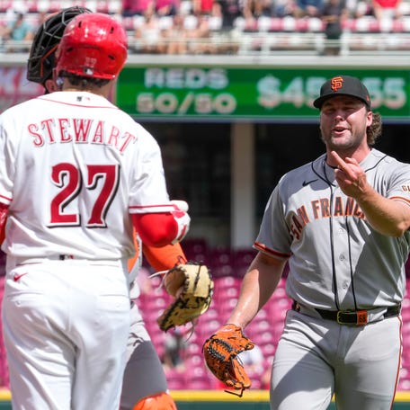 Erik Miller gestures toward Reds third baseman Sal Stewart after the final out.