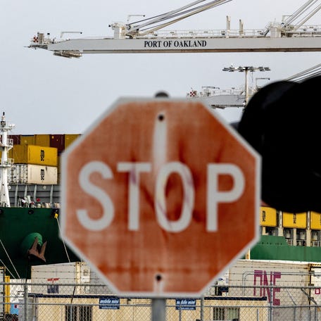 A cargo ship with shipping containers sits at the port of Oakland in February following the Supreme Court's ruling that Trump had exceeded his authority when he imposed tariffs.