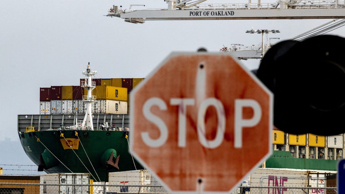 A cargo ship with shipping containers sits at the port of Oakland in February following the Supreme Court's ruling that Trump had exceeded his authority when he imposed tariffs.