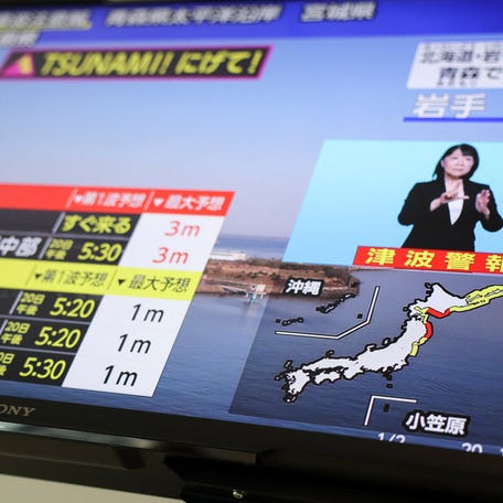 A television screen shows a news report on Japan Meteorological Agency's tsunami warning, saying it expected tsunami waves to reach large coastal areas in northern Japan after an earthquake with a preliminary magnitude of 7.4 struck on April 20, 2026.