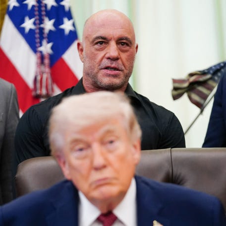 Podcaster Joe Rogan stands behind U.S. President Donald Trump, on the day President Trump signs an executive order about easing restrictions on mental health treatments, including, ibogaine, in the Oval Office of the White House in Washington, D.C., April 18, 2026. REUTERS/Nathan Howard