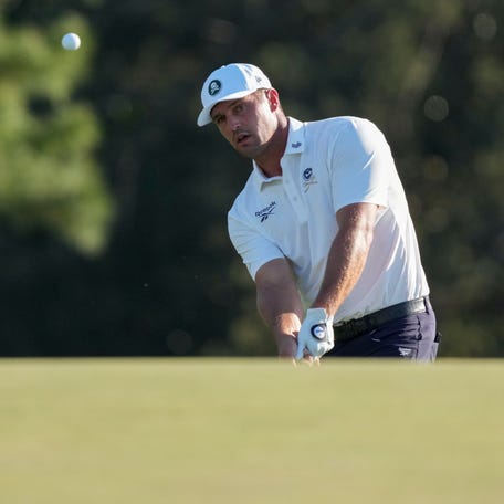 Bryson DeChambeau chips onto the 18th green during the second round of the Masters Tournament at Augusta National Golf Club.