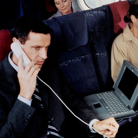 A man talks on the phone aboard a plane on June 16, 1995.