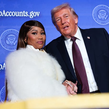 Musician Nicki Minaj (L) joins U.S. President Donald Trump on stage as he delivers remarks during the Treasury Department's Trump Accounts Summit at Andrew W. Mellon Auditorium on January 28, 2026, in Washington, DC.