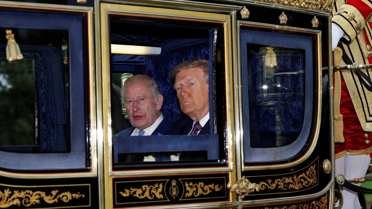 Britain's King Charles and President Donald Trump sit in a carriage during a procession through Windsor Castle, in Windsor, Britain, September 17, 2025.