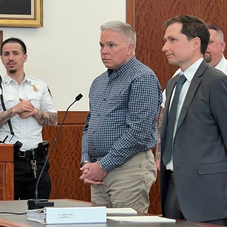 Robert S. McCluskey, in plaid shirt, in Worcester Superior Court on Friday, April 24. He is with his lawyer, Sean Smith.
