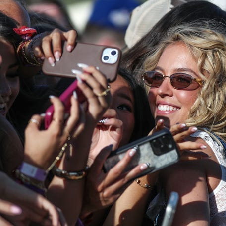 Sydney Sweeney takes photos with the front row fans just before BigXthePlug performed on the Mustang Stage during the Stagecoach Festival in Indio, Calif., April 24, 2026.