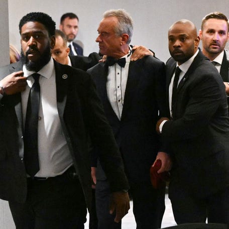 TOPSHOT - US Secretary of Health and Human Services Robert F. Kennedy Jr. is rushed out by Secret Service agents after loud bangs were heard during the White House Correspondents' dinner at the Washington Hilton in Washington, DC, on April 25, 2026. President Trump is attending the annual gala of the political press for the first time while in office. (Photo by Mandel NGAN / AFP via Getty Images)